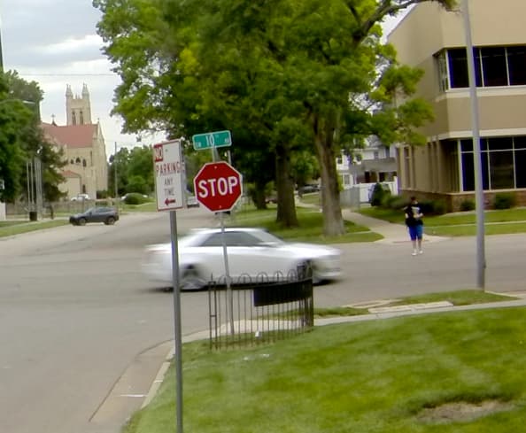 Street-level view of vehicle and pedestrian activity at a neighborhood intersection